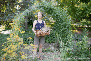 woman in vegetable garden holding onions