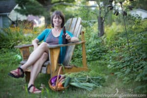 woman relaxing in garden with vegetable harvest