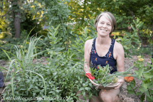 woman harvesting herbs from garden